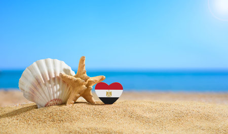 Beautiful beach in Egypt. Flag of Egypt in the shape of a heart and shells on a sandy beach.の写真素材