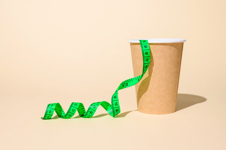 The concept of diet and the rejection of fast food. Measuring green tape and a cup of coffee.の写真素材
