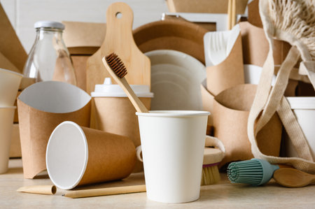 Concept of zero waste and environmental protection. Paper cup with a wooden toothbrush on the background of eco-friendly items. Selective focus on a toothbrush.の写真素材