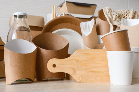 The concept of zero waste and nature protection. Disposable tableware made of paper and cardboard and cutting board made of bamboo.の写真素材