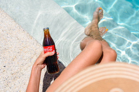 Novorossiysk - Russia, July 2022: A girl is relaxing near the pool with a bottle of Coca-Cola. view from above.のeditorial素材