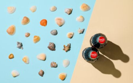 Vladimir - Russia, December 2022: Abstract seashore and two bottles of Coca Cola. Top view, selective focus on the logo. summer vacation conceptのeditorial素材