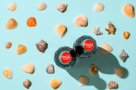Vladimir - Russia, December 2022: Two bottles of Coca-Cola on the background of seashells. Top view, selective focus on caps with logo. vacation concept.のeditorial素材