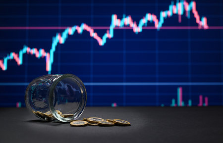 The concept of investment and financing. Glass jar with coins on the background of financial charts. selective focusの写真素材