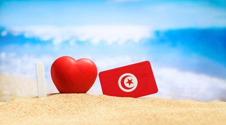 I love Tunisia. Flag of Tunisia on the beach with a red heart. vacation and travel concept.の写真素材