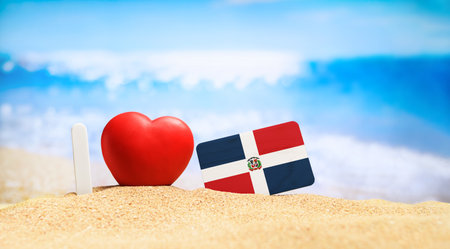 I love Dominican Republic. Flag of Dominican Republic and Barbuda on the beach with a red heart. vacation and travel concept.の写真素材