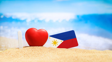 I love the Philippines. Flag of the Philippines on the beach with a red heart. vacation and travel concept.の写真素材