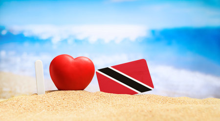 I love Trinidad and Tobago. Flag of Trinidad and Tobago on the beach with a red heart. vacation and travel concept.の写真素材