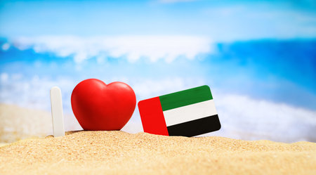 I love United Arab Emirates. Flag of United Arab Emirates on the beach with a red heart. vacation and travel concept.の写真素材