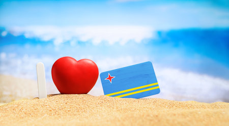 I love Aruba. Flag of Aruba on the beach with a red heart. vacation and travel concept.の写真素材