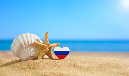 Flag of Russia in the shape of a heart and shells on a sandy beach.の写真素材
