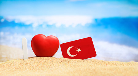 I love Turkey. Flag of Turkey on the beach with a red heart. vacation and travel concept.の写真素材