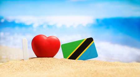 I love Tanzania and Zanzibar. Flag of Tanzania on the beach with a red heart. vacation and travel concept.の写真素材