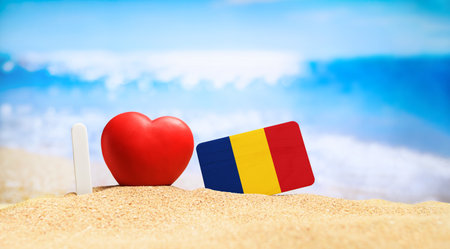 I love Romania. Flag of Romania on the beach with a red heart. vacation and travel concept.の写真素材