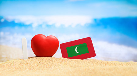 I love Maldives. Flag of Maldives on the beach with a red heart. vacation and travel concept.の写真素材