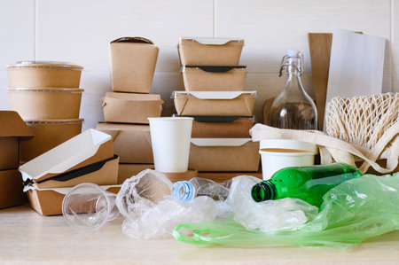 Pile of plastic bags and plastic bottles on the background of eco-friendly items made of biodegradable paper and cardboard. Zero waste concept. selective focusの写真素材