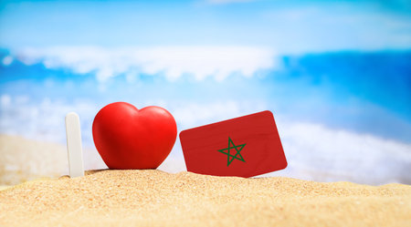 I love Morocco. Flag of Morocco on the beach with a red heart. vacation and travel concept.の写真素材