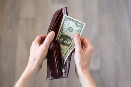 The girl shows the last dollar in her wallet. concept of poverty and unemployment