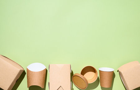 Eco-friendly disposable tableware made of paper on a green background at the bottom of the frame. copy spaceの写真素材