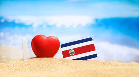 I love Costa Rica. Flag of Costa Rica on the beach with a red heart. vacation and travel concept.の写真素材