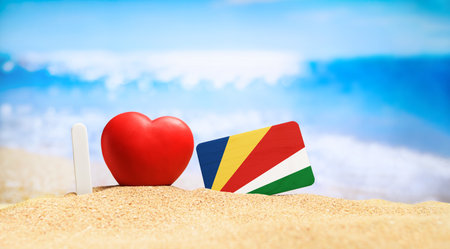 Flag of Seychelles on the beach with a red heart. vacation and travel concept.の写真素材