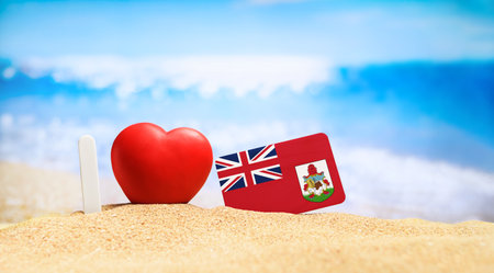 I love Bermuda. Flag of Bermuda on the beach with a red heart. vacation and travel concept.の写真素材