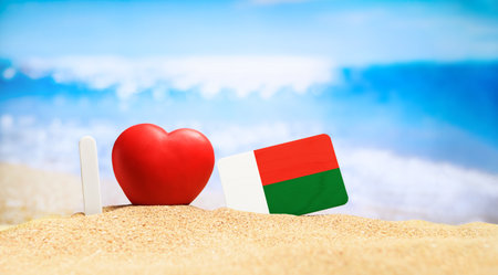 Flag of Madagascar on the beach with a red heart. vacation and travel concept.の写真素材