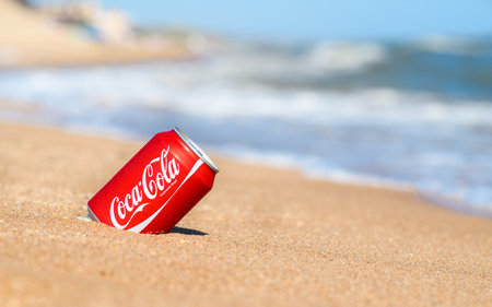 Anapa, Russia - July 2023: Can of cold Coca-Cola on the beach.