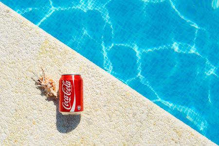 Anapa, Russia - July 2023: Drink Coca Cola and seashell on the edge of the pool on a hot sunny day.