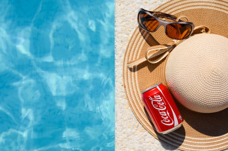 Anapa, Russia - July 20, 2023: Seat by the pool in the hotel and a jar of Coca-Cola with a hat and sunglasses. summer holiday concept. View from aboveのeditorial素材