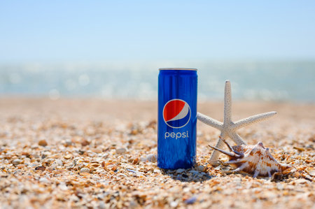Anapa, Russia - July 30, 2023: Tropical beach with shells and a cold can of Pepsi.のeditorial素材
