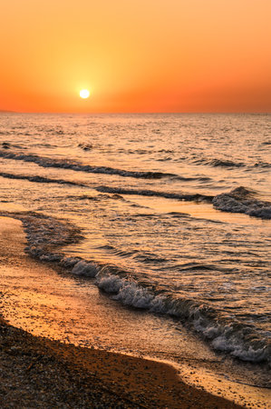 Sea waves and golden sunset. Vertical seascape. Selective focus. evening sunset on the sea.の写真素材