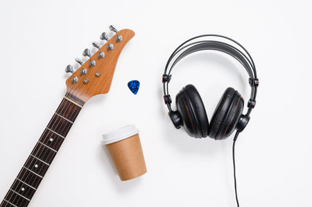 Passion for music. Guitar headphones and a coffee cup on a white background. Selective focus.の写真素材
