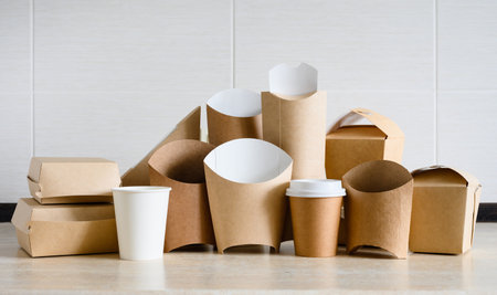 Large set of various eco-friendly disposable food packaging on a light background. Panorama with paper utensils for food delivery.の写真素材