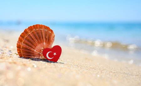 Sandy beach in Turkey. Turkey flag in the shape of a heart and a large shell. A wonderful seaside resort.の写真素材