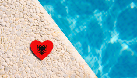 Albania flag in the shape of a heart near the pool in the hotel.