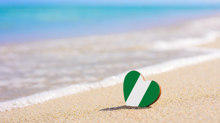 Flag of Nigeria in the shape of a heart on a sandy beach. The concept of the best holiday in Nigeriaの写真素材