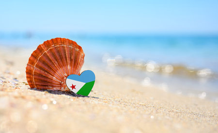 Sandy beach in Djibouti. Djibouti flag in the shape of a heart and a large shell.の写真素材