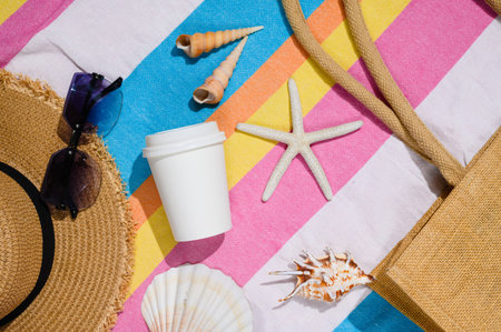 A white paper cup on the beach. Space for a logo. Eco-friendly cup.