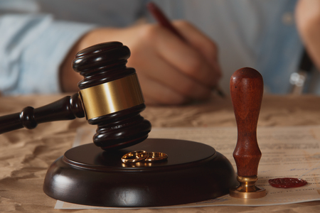 Closeup of male hand signing divorce papers.の写真素材