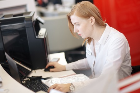 Young busy beautiful latin business woman suffering stress working at office computerの写真素材