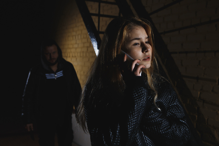 Thief with knife attack his victim on night streetの写真素材