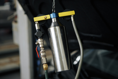 Professional mechanic testing diesel injector in his workshop.の写真素材