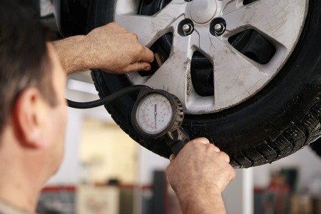 Mechanician changing car wheel in auto repair shop