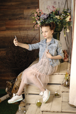 children, technology and communication concept - smiling girl texting on smartphone and lying iat homeの写真素材