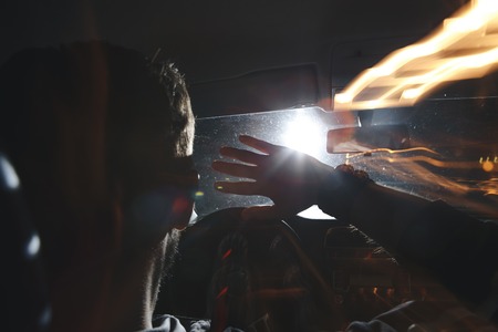 Dont drink and drive concept, Drunk and driving a car at night with a bottle of alcoholの写真素材