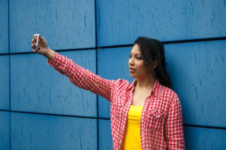 Young teenage girl taking photo by mobile phone.