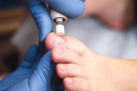 Master using professional instruments when doing pedicure. Pedicure treatment in beauty salon. Close up conceptの写真素材