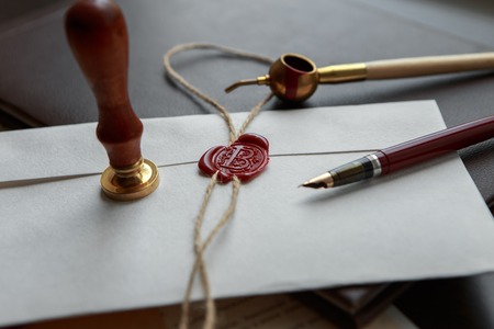 Fountain pen and old notarial wax seal on document, closeup