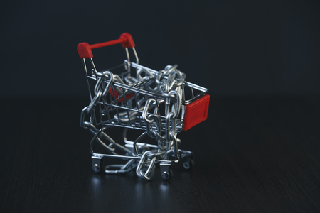 basket for purchases in which there is a metal chain, part of the chain fell to the floor, the background blueの写真素材